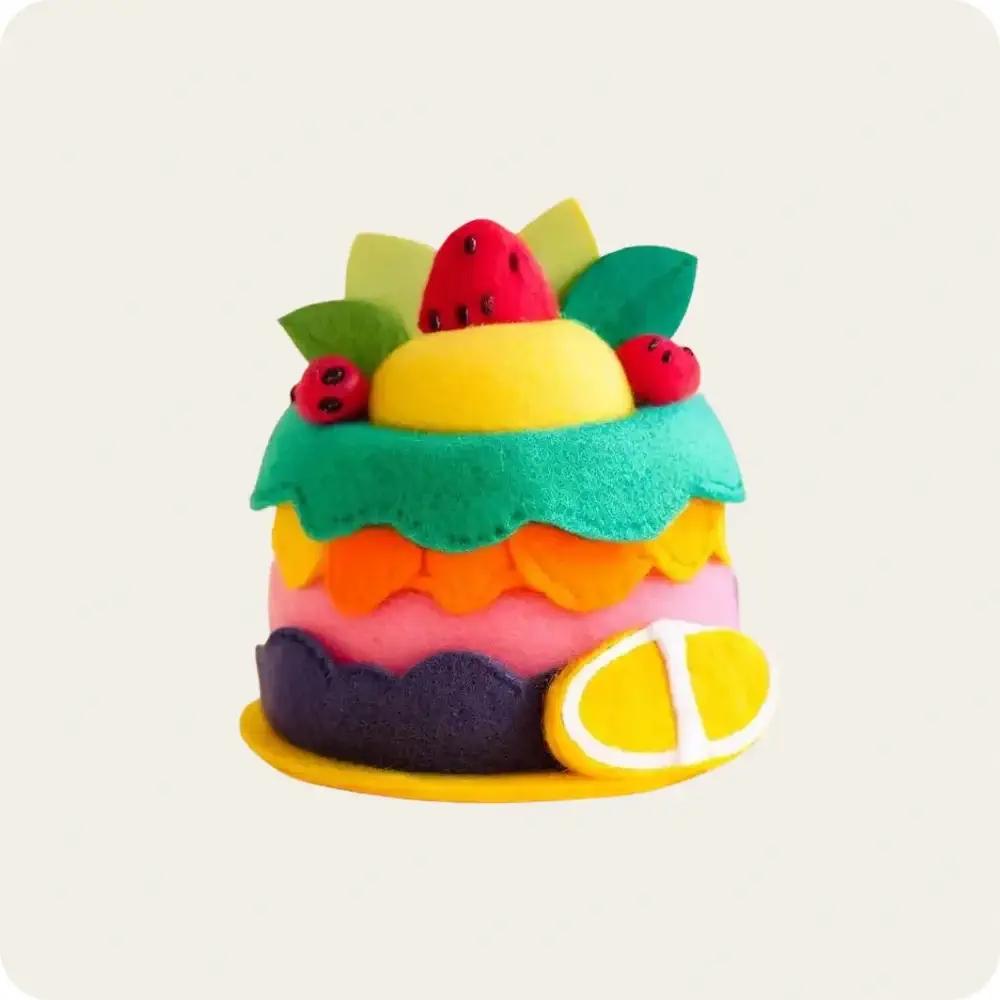 Colorful felt fruit cake made from felt materials, showcasing vibrant layers of fruits and decorations, perfect for play or decor.