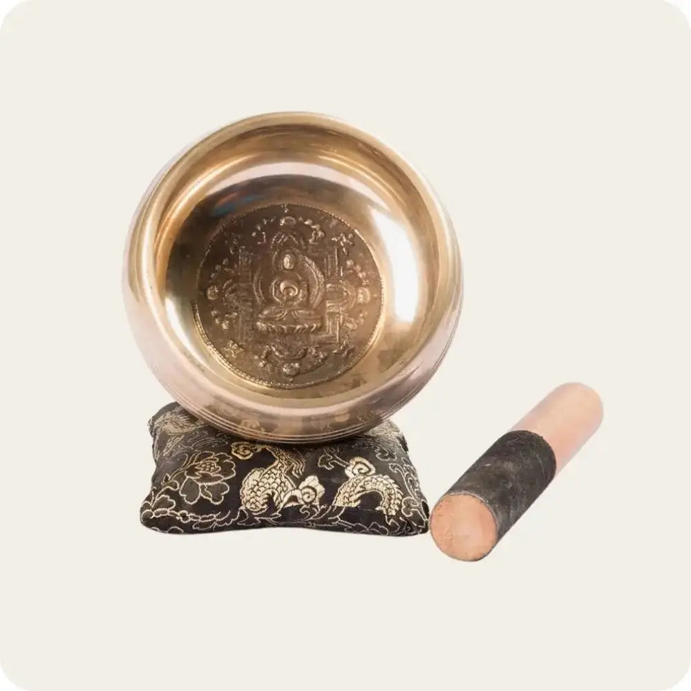 Tibetan singing bowl with cushion and wooden striker, ideal for meditation and sound therapy.