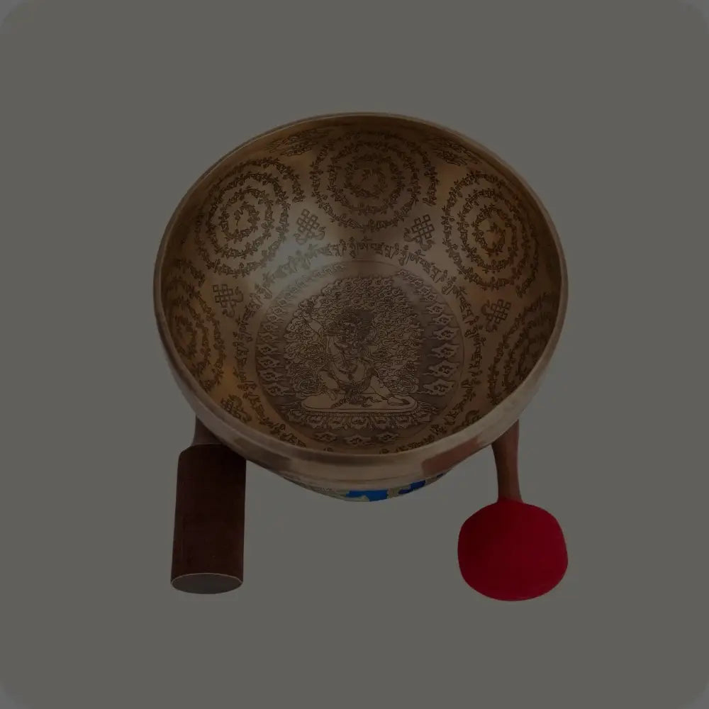 Beautifully engraved singing bowl with intricate design, paired with a wooden mallet and red-felt striker, ideal for meditation and sound healing.